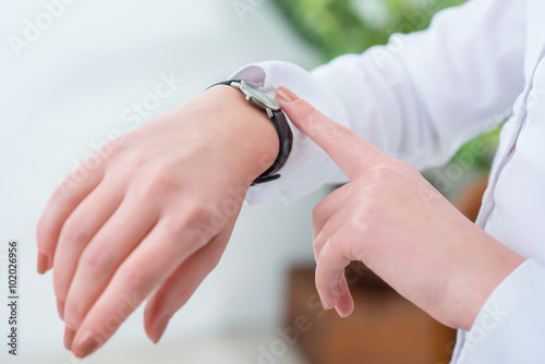 Busy woman looking at her wrist watch 