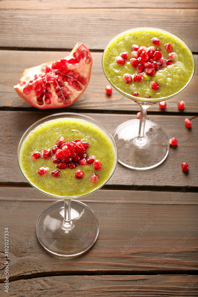 Fresh healthy kiwi drink with pomegranate on wooden background Fresh healthy kiwi drink with pomegranate on wooden background