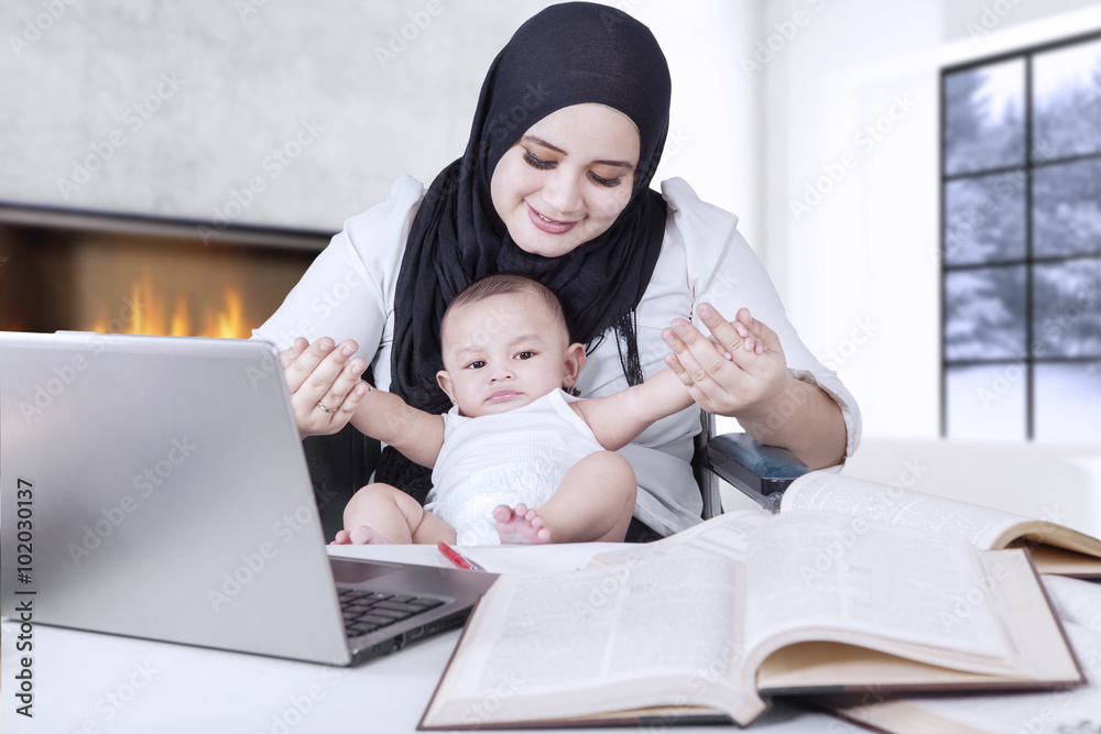 Mother Working while Playing with her Baby Mother Working while Playing with her Baby