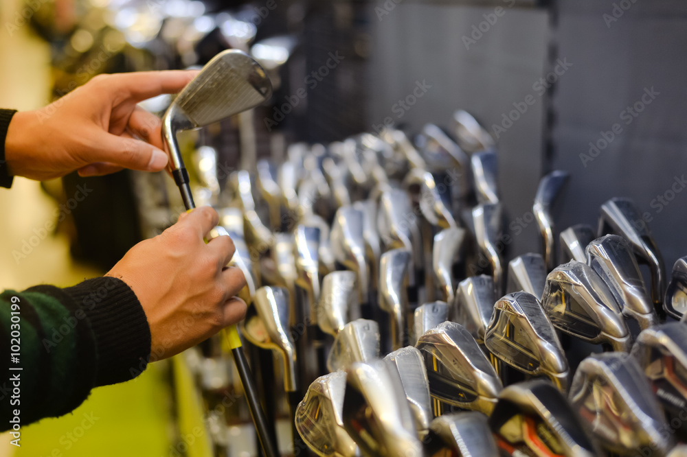 Person holding with hand golf club in a Golf Shop - obrazy, fototapety, plakaty 