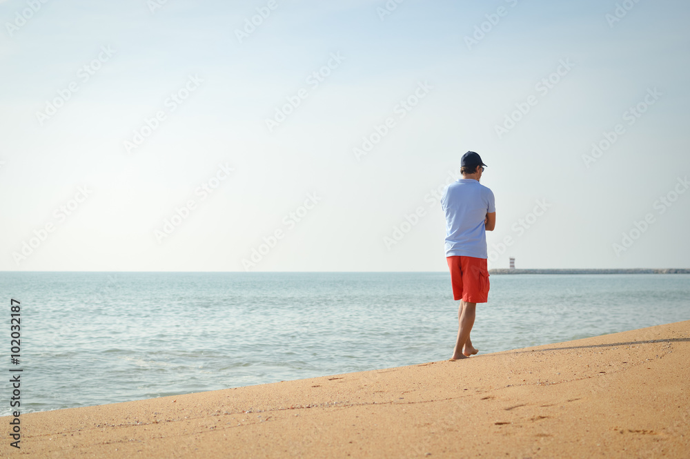 Man standing with the ocean in the background. Man standing with the ocean in the background.