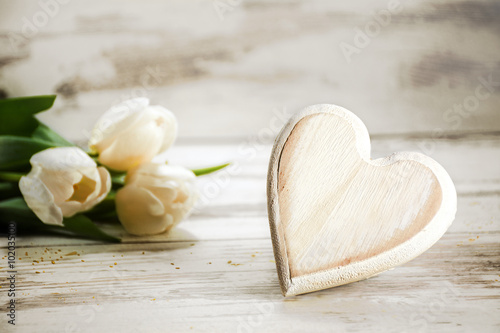 heart of wood and tulips on a white wooden background  love concept