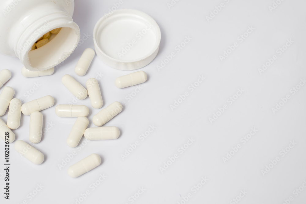Pills from bottle on the white Pills from bottle on the white