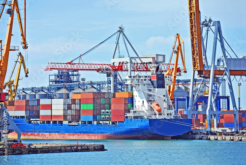 Container stack and ship under crane bridge