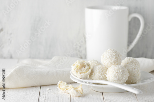 Coconut candies pile in white plate and cup