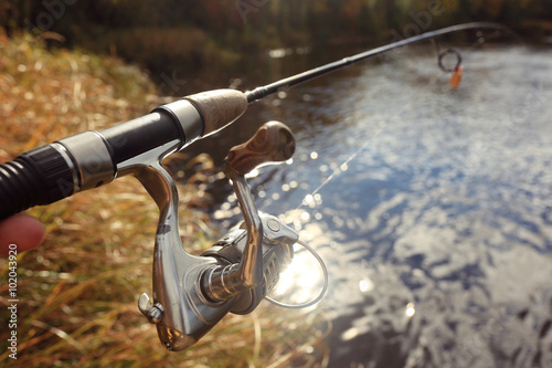 Autumn fishing spinning in his hand