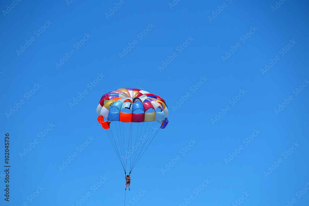 Parasailing girl against a blue sky Parasailing girl against a blue sky