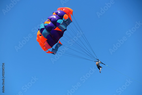 Parasailing girl against a blue sky photo