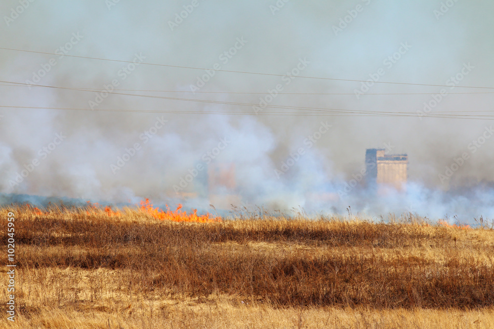 Fototapeta premium Line of the fire coming to industrial city district - burning me