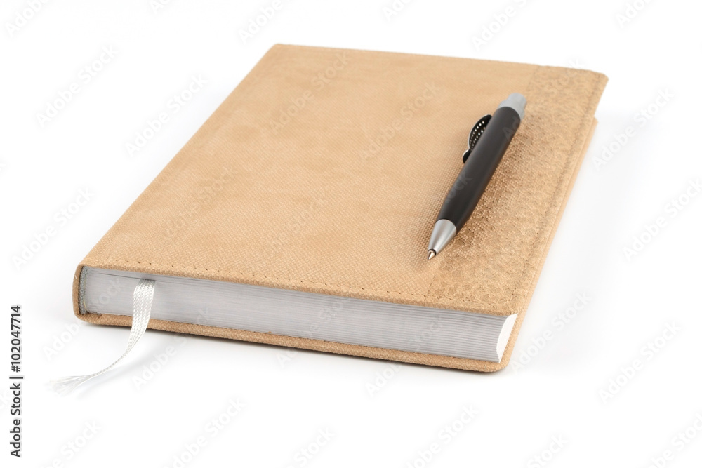 Black ballpoint pen on a beige diary Black ballpoint pen on a beige diary