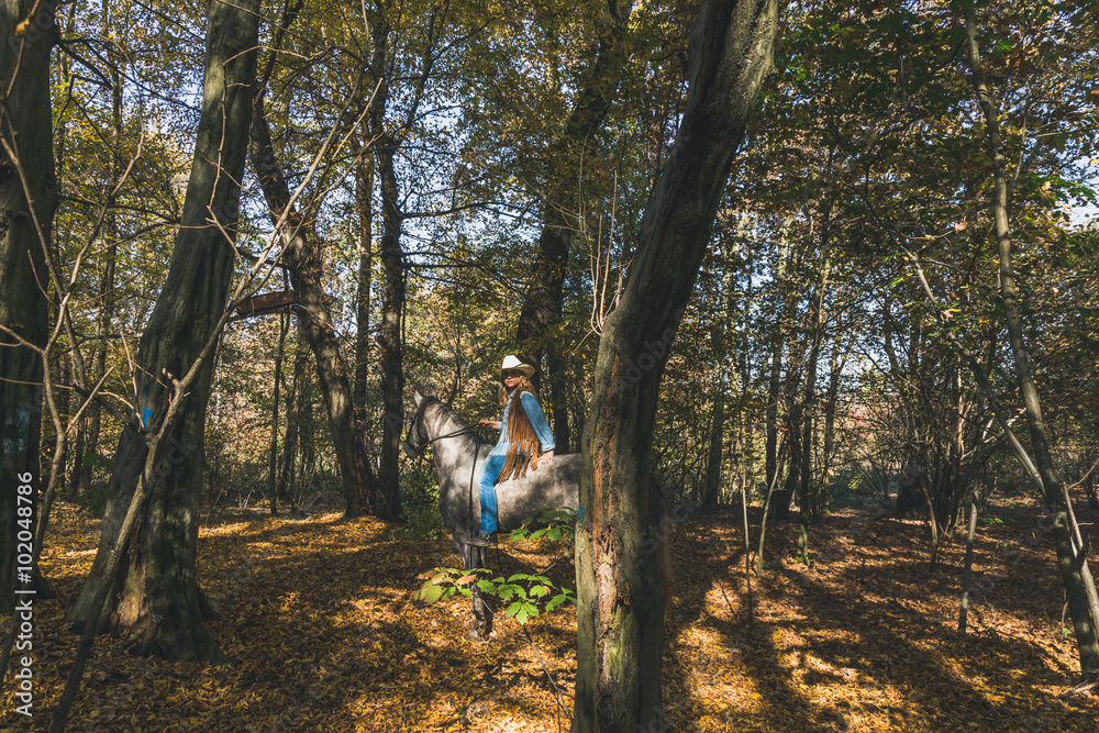 Fototapeta premium Pretty girl riding her grey horse