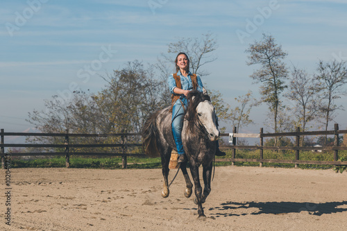 Pretty girl riding her grey horse