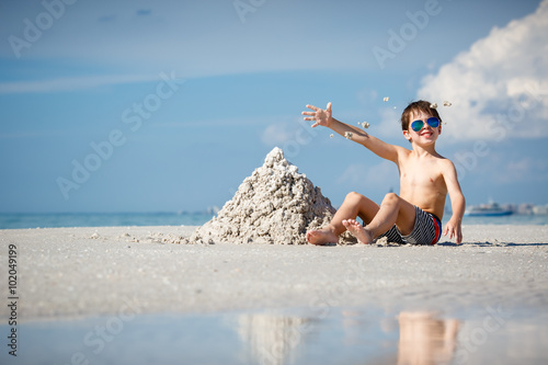 Cute little son building sand castle at beach on Florida