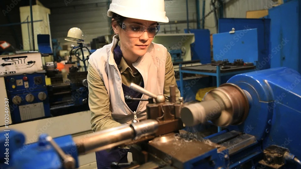 Metal worker woman using machine in workshop Metal worker woman using machine in workshop