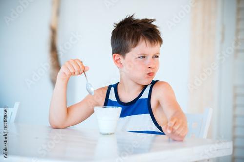 Quadro em tela Smiling little boy refuses to eat delicious yogurt