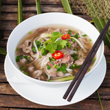 Traditional Vietnamese beef soup pho on a wooden background