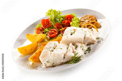 Fish dish - boiled fish fillet, baked potatoes and vegetables 
