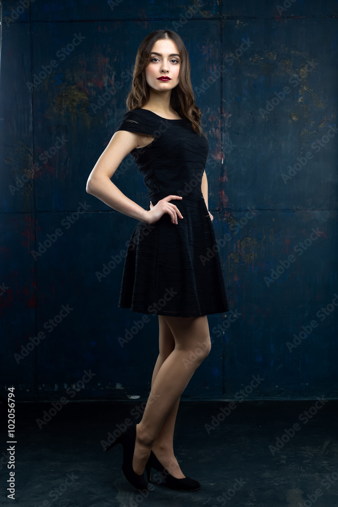 Beautiflul young woman wearing black dress on black background