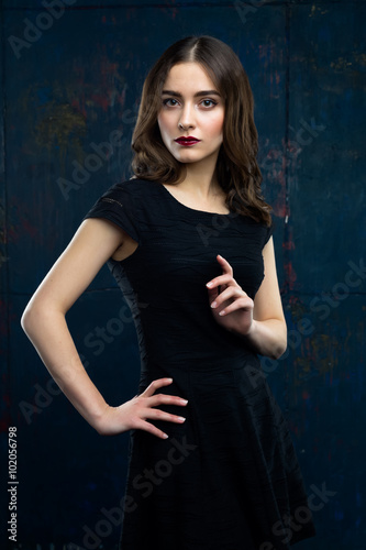 Beautiflul young woman wearing black dress on black background