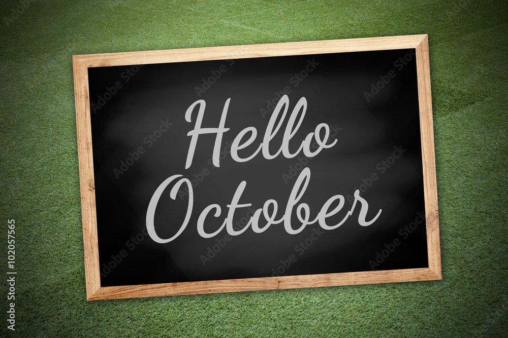 Obraz premium Hello October on chalk board and green field background and text