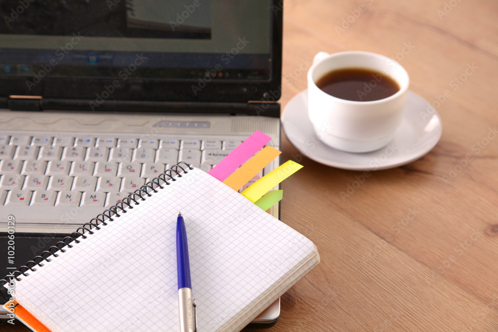 Office table with blank notepad and laptop Office table with blank notepad and laptop
