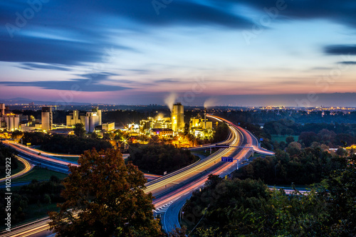 Leuchtspuren von Autos auf der Autobahn A60 bei Mainz an einer Fabrik