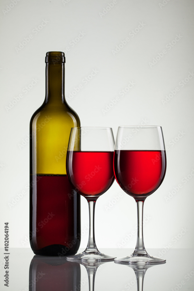 Glass of wine and bottle on white with copy space