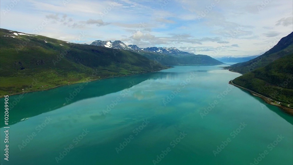 Scenic flight above Lyngen fjord in arctic Norway with perfect reflections of surrounding mountains on calm surface. Aerial 4k Ultra HD. Scenic flight above Lyngen fjord in arctic Norway with perfect reflections of surrounding mountains on calm surface. Aerial 4k Ultra HD.