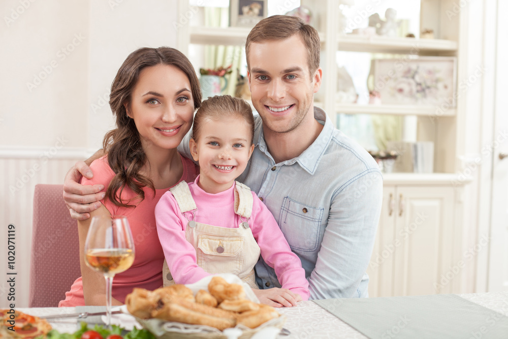 Cute husband and wife are dining with their child