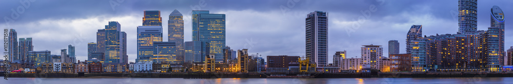 Wide panoramic skyline of Canary Wharf, the worlds leading financial district at blue hour - London, UK