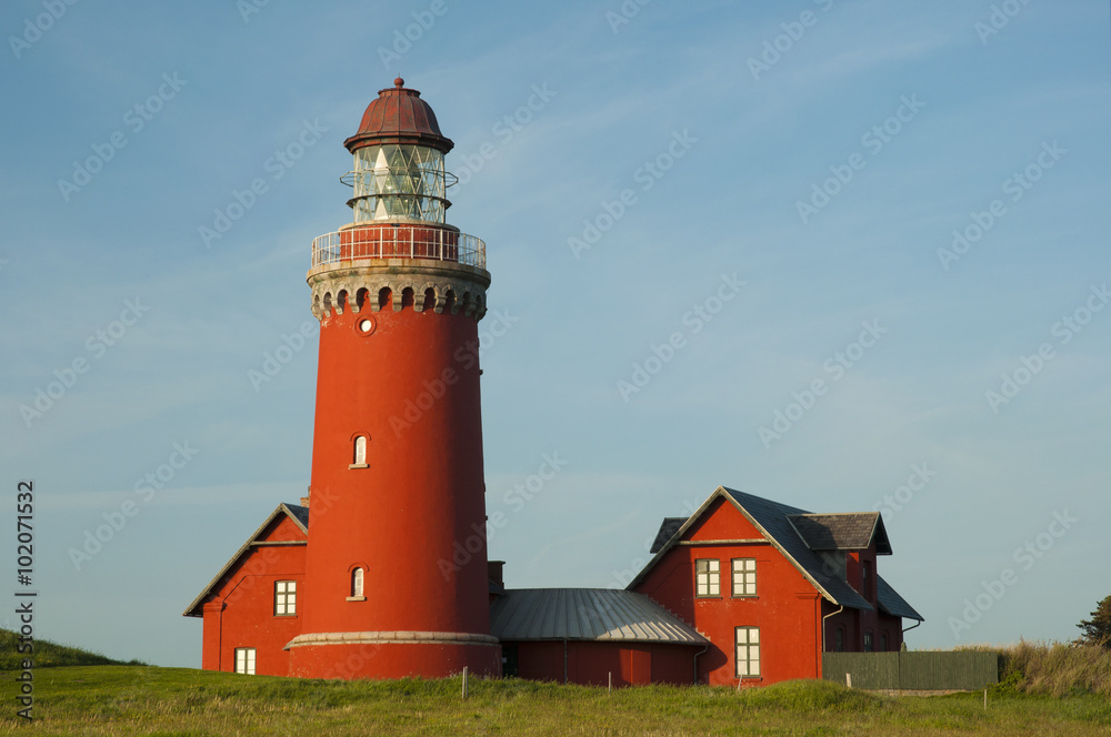 beautiful red Lighthouse Bovbjerg Fyr with green grass and blue sky, Danish North Sea coast, Jutland, Denmark, Europe
