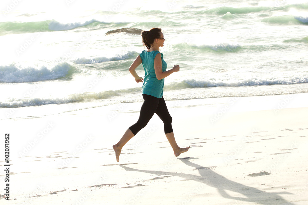 Young woman running along the sea shore Young woman running along the sea shore