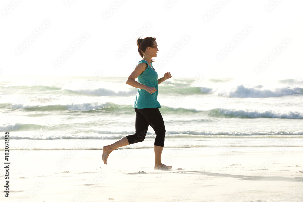 Portrait of young woman running along the beach Portrait of young woman running along the beach