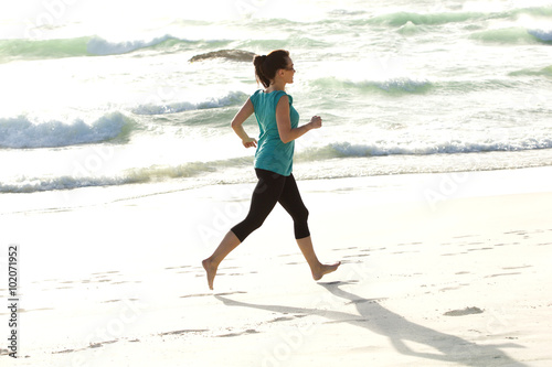 Young woman running along the sea shore