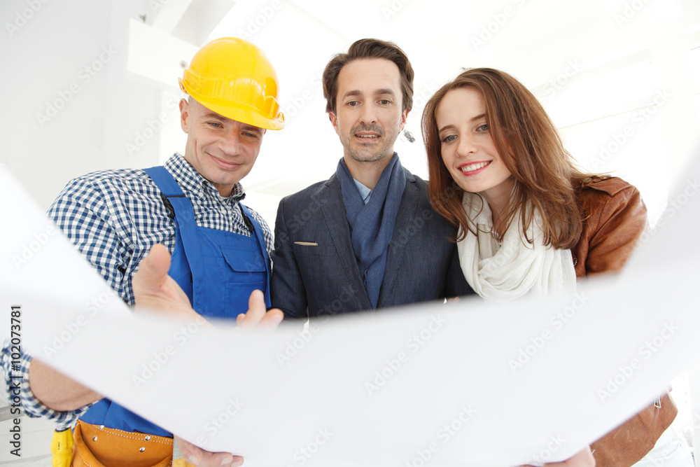 Worker shows house design plans Worker shows house design plans