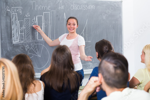 student standing near blackboard