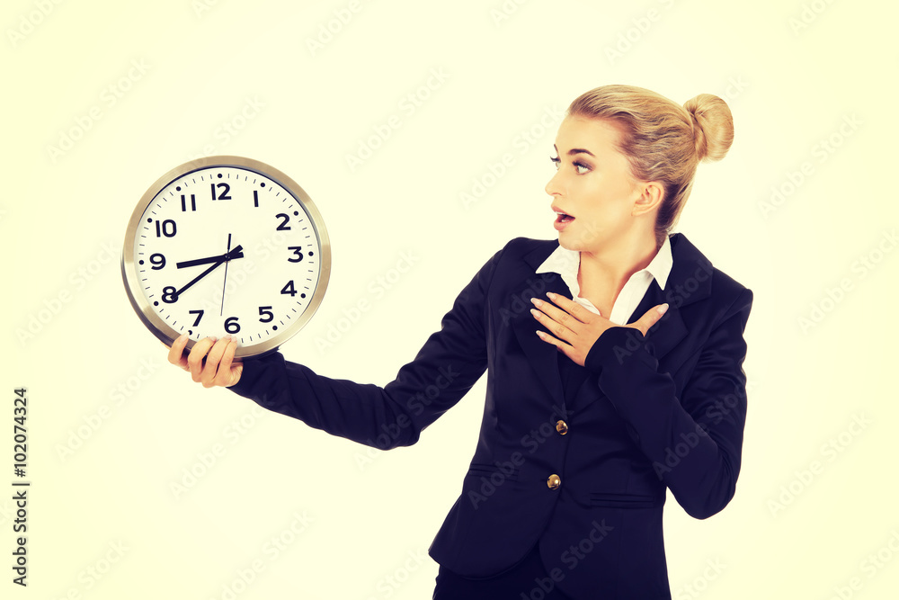 Young businesswoman terrified looks at the clock Young businesswoman terrified looks at the clock