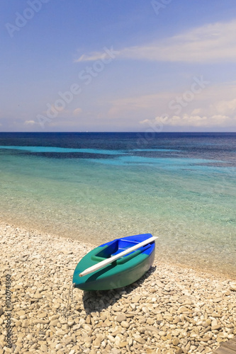 Canoe and kayak on pebble beach, Monodendri beach, Paxos island, Greece. 