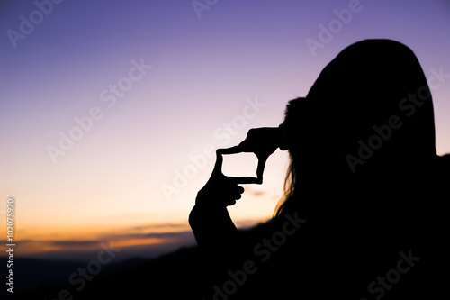 The woman hand framing distant.