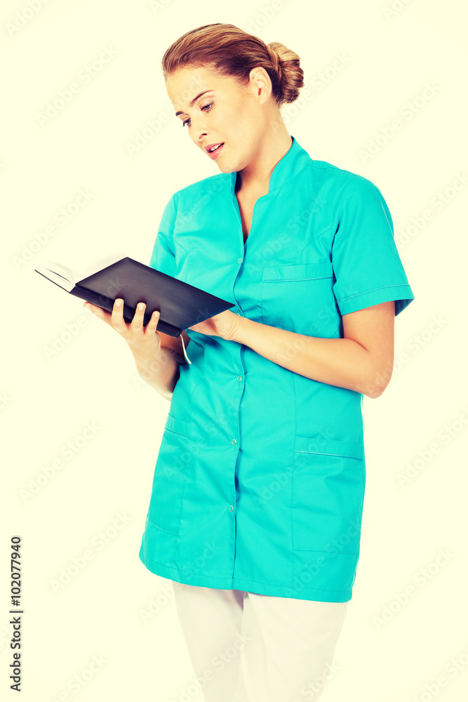 Young female doctor or nurse holding black notes Young female doctor or nurse holding black notes