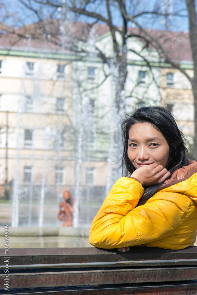 Young woman resting on a bench in the park, České Budejovice, Czech republic