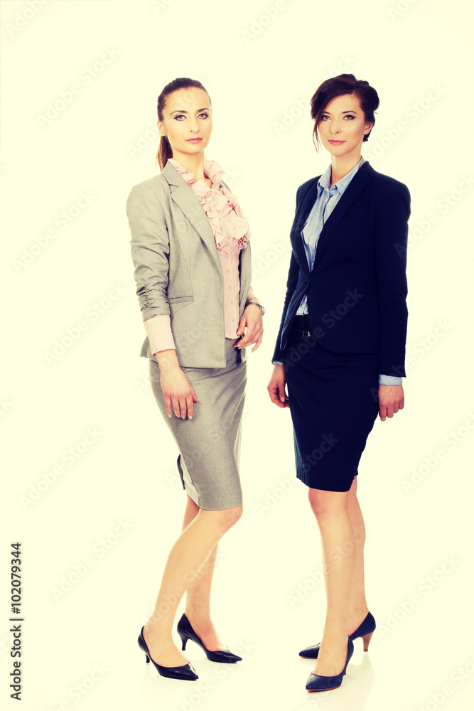 Two women wearing office outfits. Two women wearing office outfits.