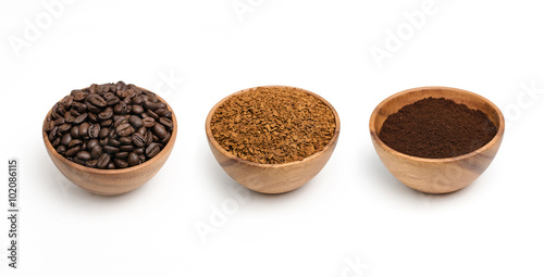 Preparing roasted coffee beans, granulated coffee and coffee powder in wooden bowl.