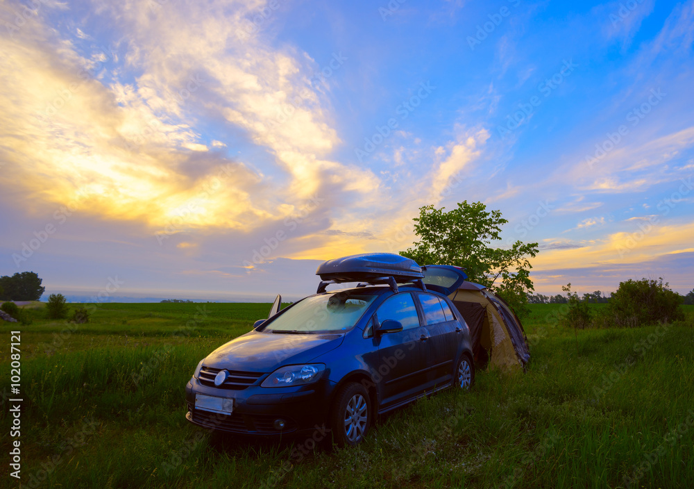 The camping with a tent and car at sunrise in field. The camping with a tent and car at sunrise in field.