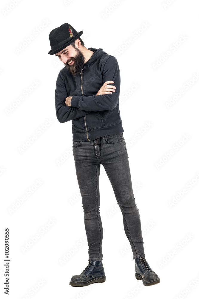 Happy spontaneous laughing hipster with fedora hat looking down. Full body length portrait isolated over white studio background. Happy spontaneous laughing hipster with fedora hat looking down. Full body length portrait isolated over white studio background.