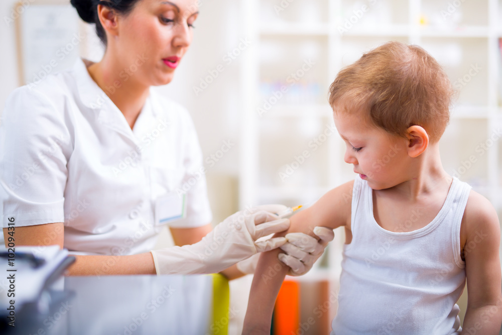 Pediatrician makes vaccination to small boy Pediatrician makes vaccination to small boy