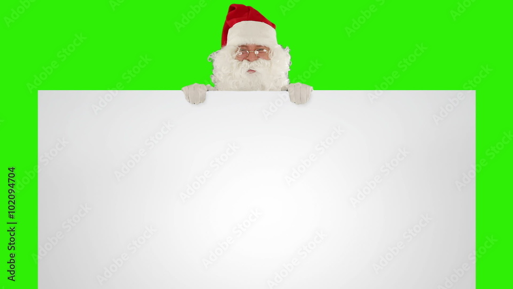 Santa Claus appears behind a white sheet with space for tex Green Screen Santa Claus appears behind a white sheet with space for tex Green Screen
