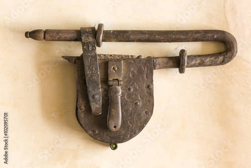 Antique padlock on adobe wall, Oaxaca, Mexico photo