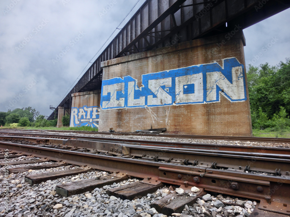 Railroad tracks with bridge and graffiti - landscape photo