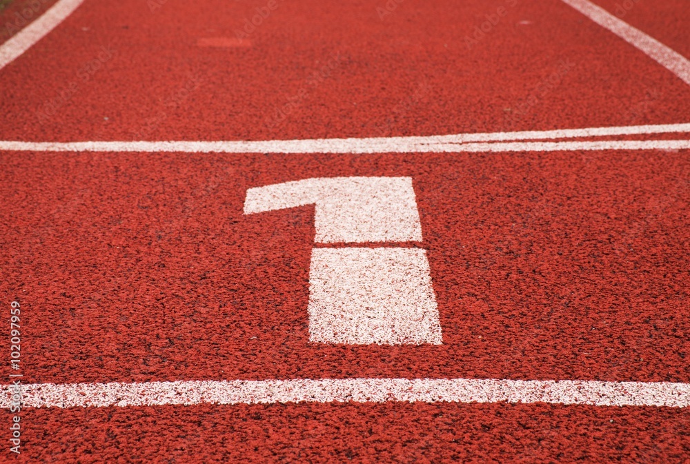 Number one. White track number on red rubber racetrack, texture of running racetracks in stadium Number one. White track number on red rubber racetrack, texture of running racetracks in stadium